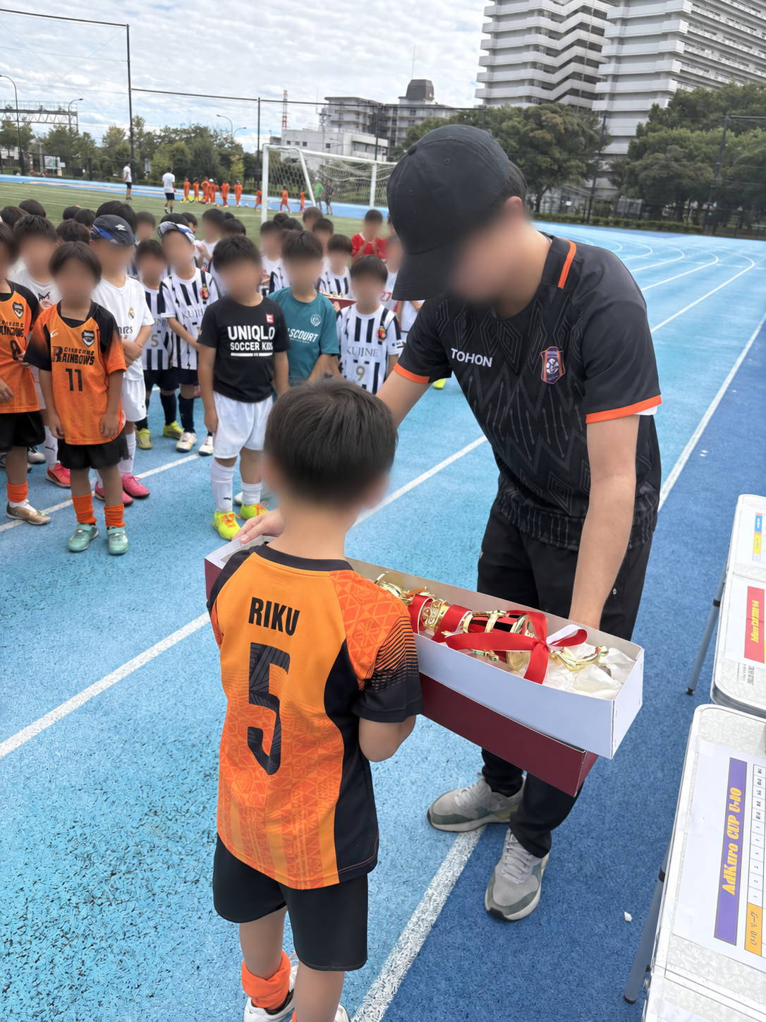 AdKura CUPの表彰式で、選手にトロフィーを手渡す様子